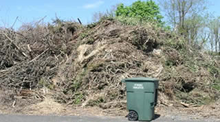 Yard waste piled 12' high before being shredded at the facility.